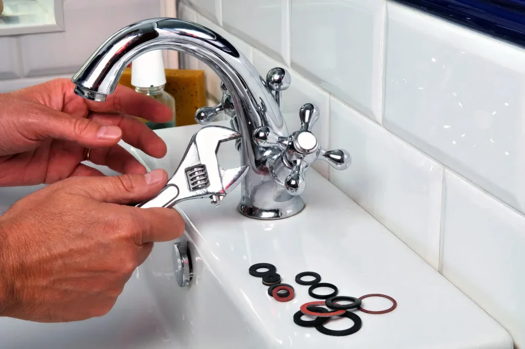 Plumber performing maintenance on a bathroom faucet in Lawrenceville