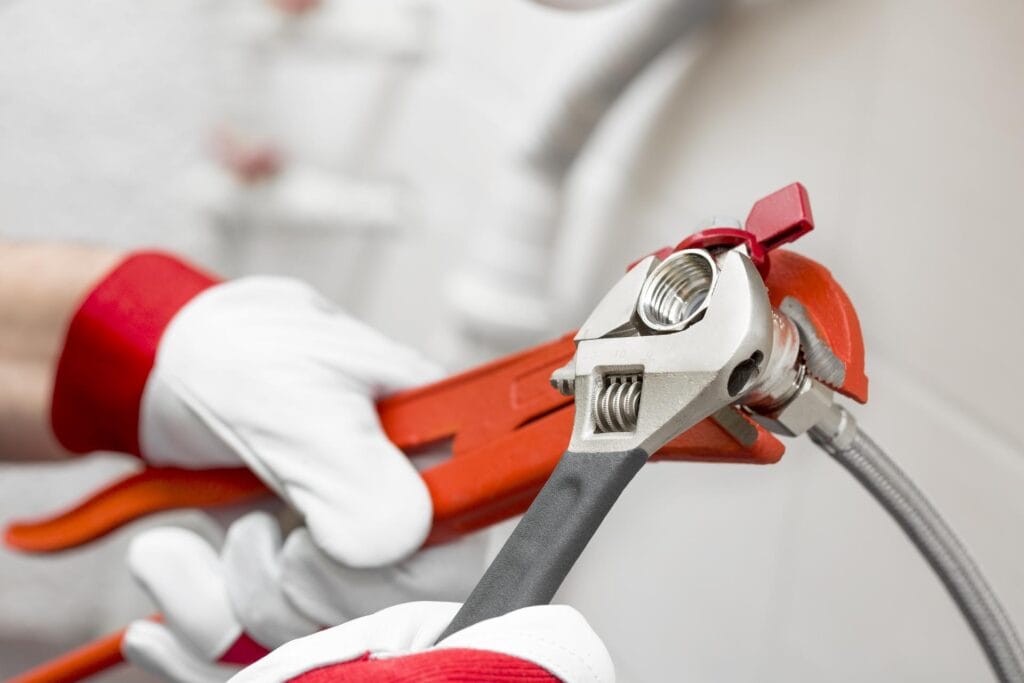 Plumber holding pipe wrenches for an emergency repair in Lawrenceville