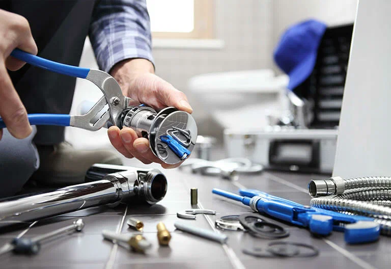 Technician repairing a plumbing fixture with professional tools in Lawrenceville