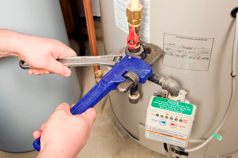 Plumber repairing a water heater valve in Lawrenceville